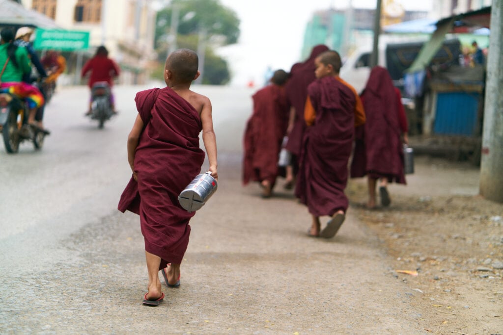 Young Monk Walking with Container