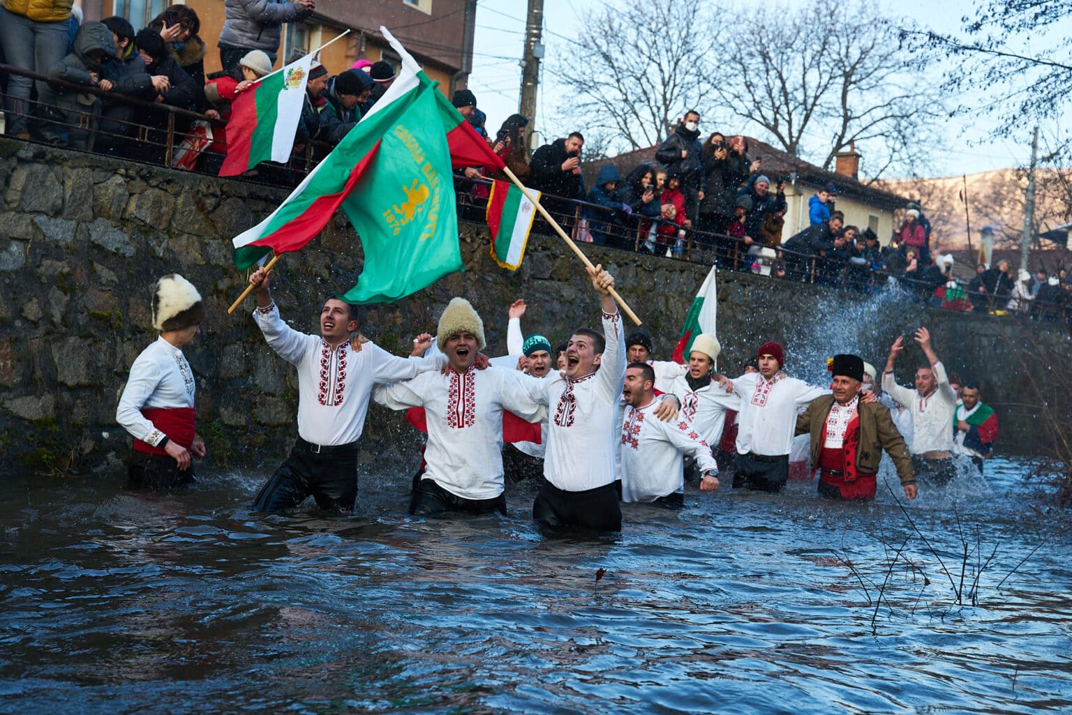 Men waving flags in river